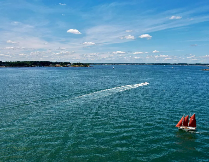 Sailing boat with red sails on a calm sea