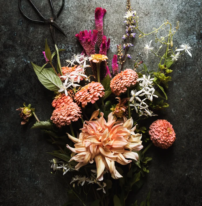 Wild Meadow arrangement of loose seasonal stems laid on a dark bench